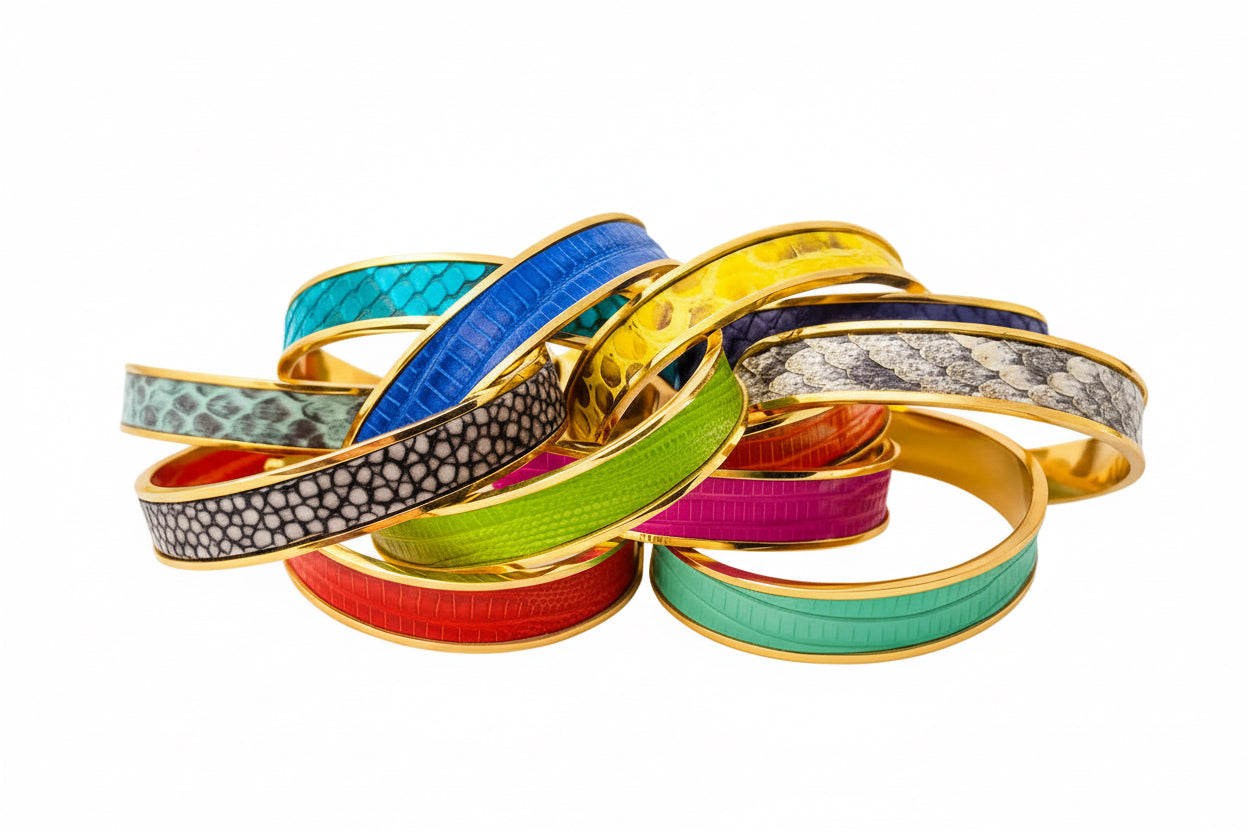 Stack of colorful bracelets with gold bands on a white background